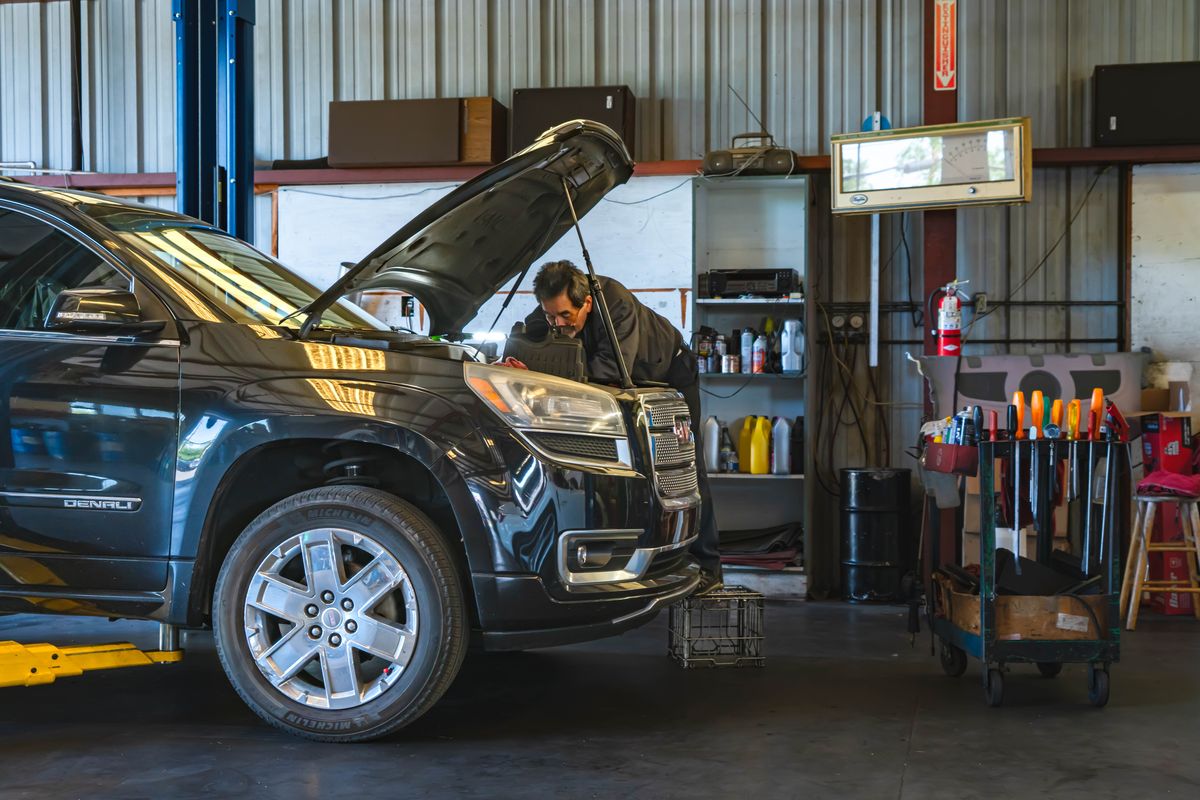 Technician performing scheduled maintenance on an SUV